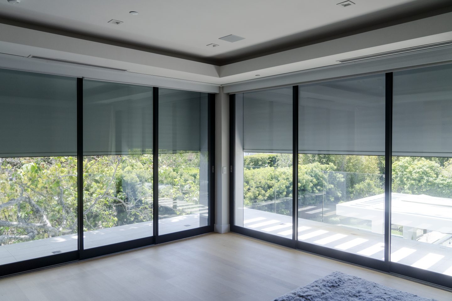 clean room showing floor to ceiling windows with exterior roller shade